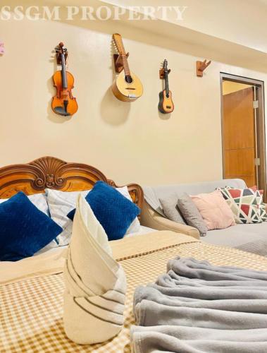 a bedroom with a bed with guitars on the wall at Mactan Newtown Feels like Home in Lapu Lapu City