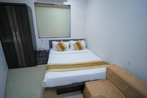 a bedroom with a large bed and a window at Hotel Skylink Hospitality Mahalaxmi in Mumbai