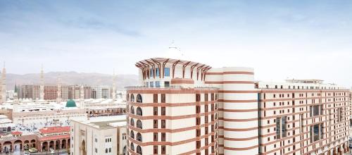a tall white building with a bird on top of it at Pullman Zamzam Madina in Al Madinah