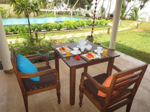 a table and two chairs with food on it at Lanka Beach Boutique Bungalows & Grand Villa in Tangalle