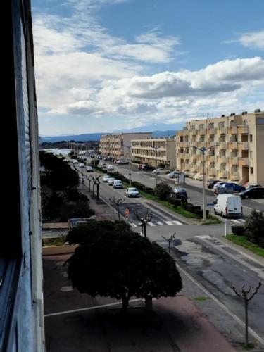 - une vue sur une rue de la ville avec des bâtiments et un arbre dans l'établissement STUDIO Bis - PLAGE, à Port-la-Nouvelle