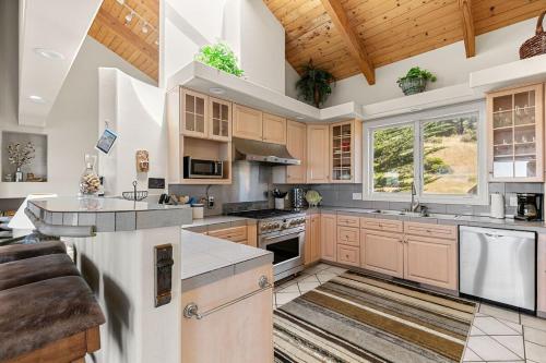 a kitchen with wooden cabinets and a wooden ceiling at Stunning views near beaches and bluff in Sea Ranch