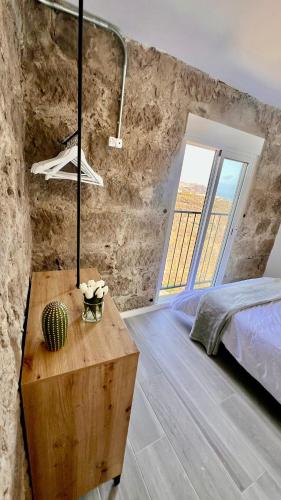 a bedroom with a bed and a large window at Hacienda Adejo in Moya