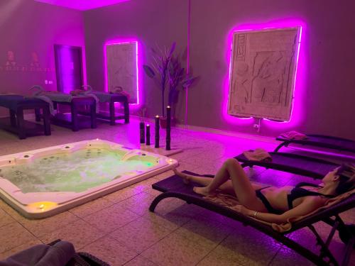 a woman laying in beds in a room with a hot tub at Royal Regency Club - Ultra All Inclusive in Sharm El Sheikh