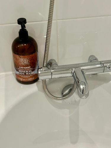 a bottle of soap is sitting next to a toilet at Luxury 2 bedroom apartment in Aberdeen in Kirkton of Skene