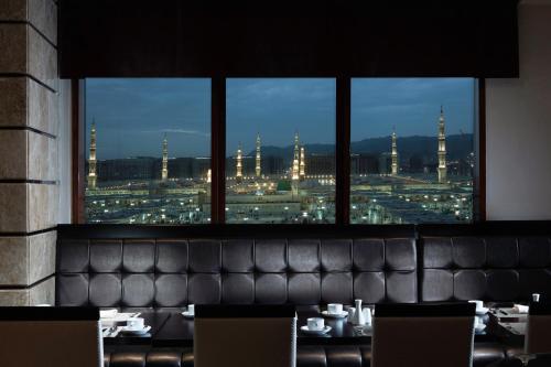a restaurant with a view of a city at night at Pullman Zamzam Madina in Al Madinah