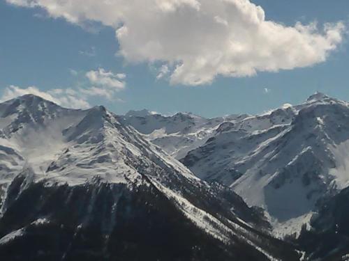 a snow covered mountain range with a cloudy sky at Petit Appart de Charme Eau chaude solaire Rénovation 2021 Wifi disponible Belvedere 5 in Saint-Luc