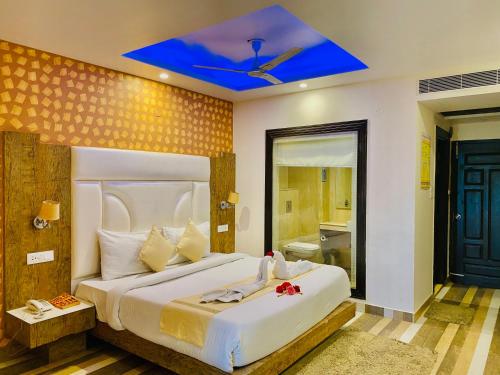 a bedroom with a large bed with a blue ceiling at Aachman Nature Valley Resort Mashobra BY NAINA STAYCATION- Private Parking - Balcony and valley view Rooms in Shimla