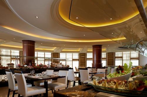 a dining room with tables and chairs in a restaurant at Pullman Zamzam Madina in Al Madinah