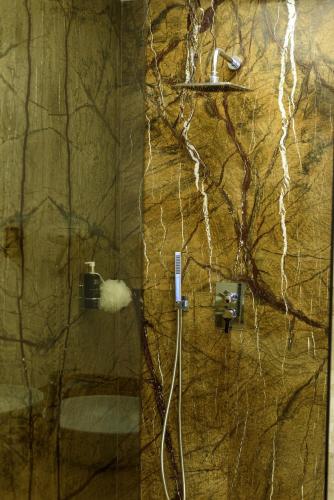 a bathroom with a shower with a stone wall at Astria Mediterana - Complex Novum in Olimp