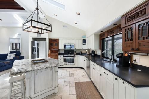 a large kitchen with white cabinets and a large island at Serenity in Captiva