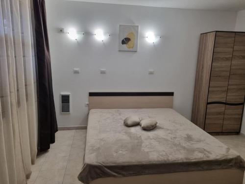 a bedroom with a bed with two pillows on it at К-с Сън Коуст in Sveti Vlas
