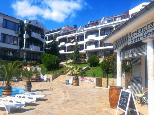 a resort with a swimming pool in front of a building at К-с Сън Коуст in Sveti Vlas