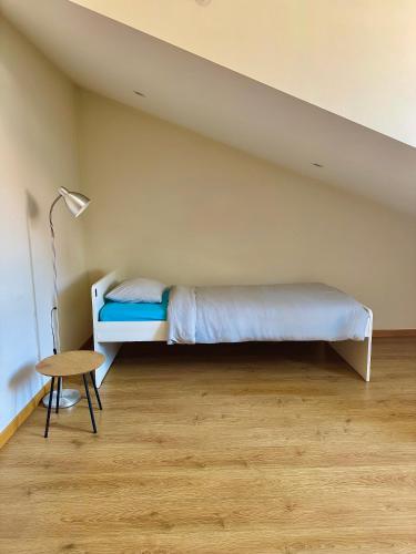 a bedroom with a bed and a lamp and a table at Âmbar Guest House in Braga