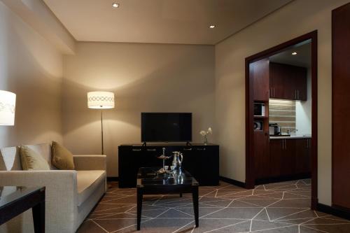 a living room with a couch and a tv at Pullman Zamzam Madina in Al Madinah