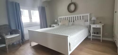a white bedroom with a white bed and a window at Ferienhaus-Loehndorf in Sinzig