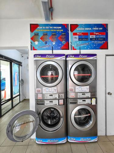 two washing machines sitting next to each other in a room at Ayer Keroh B202 6pax Cozy Stay - GXHomes in Ayer Keroh