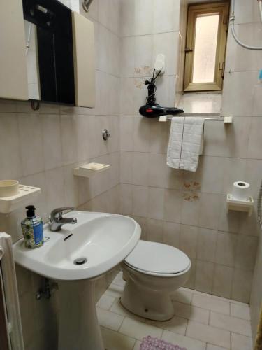 a white bathroom with a toilet and a sink at Casa di Francesca in Ruvo del Monte