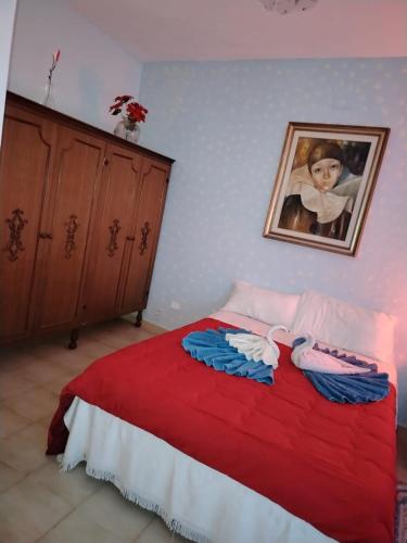 a bedroom with a red bed with a painting on the wall at Casa di Francesca in Ruvo del Monte