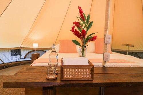a table with a vase of flowers on top of a tent at Nómada Tayrona Boutique Glamping in Santa Marta