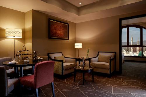 a hotel lobby with chairs and a table and a window at Pullman Zamzam Madina in Al Madinah