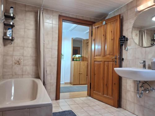 a bathroom with a tub and a sink at FeWo Taube in Schammels dorf am Brauereienweg Platz für 7 Personen in Litzendorf