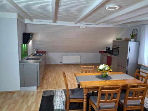 a kitchen and dining room with a table and chairs at FeWo Taube in Schammels dorf am Brauereienweg Platz für 7 Personen in Litzendorf