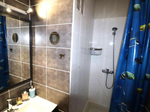 une salle de bain avec une douche avec un rideau de douche bleu dans l'établissement Duplex 3 pièces 6 pers avec clim et parking au Grau-du-Roi - FR-1-307-279, au Grau-du-Roi