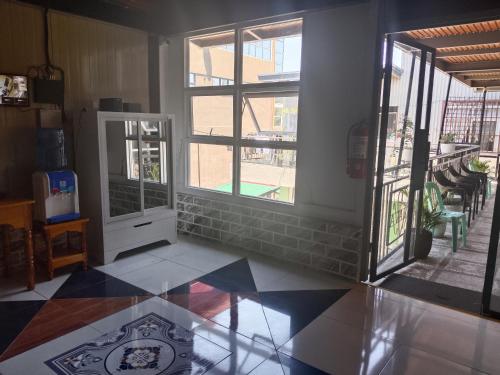 a living room with a tile floor and windows at Ahava Lodge in Cervantes