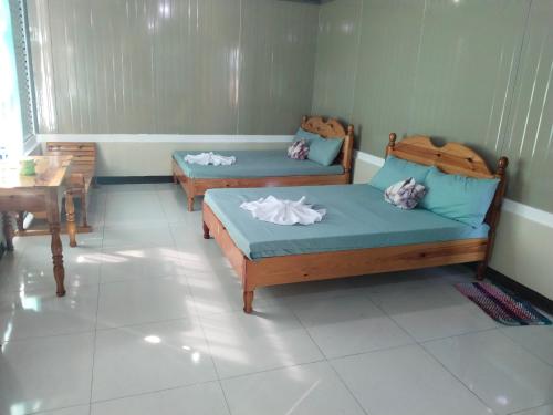 a room with two beds and a table at Ahava Lodge in Cervantes