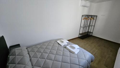 a bedroom with a bed with two towels on it at Optimus Japón in Coria del Río