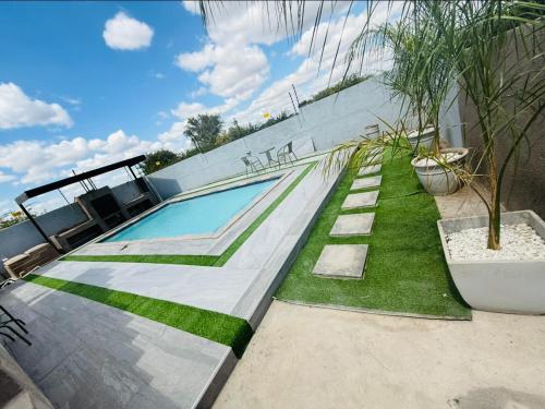 a swimming pool with grass next to a building at The Pool_deck apartment in Lebowakgomo