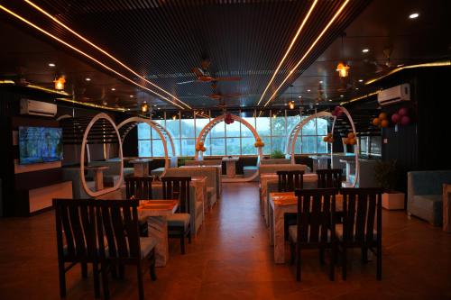 a dining room with tables and chairs in a restaurant at Hotel Royal Plaza in Rishīkesh