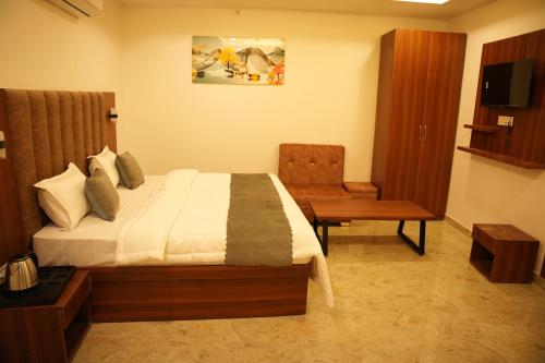 a bedroom with a bed and a desk and a chair at Hotel Royal Plaza in Rishīkesh