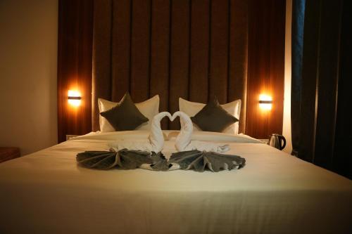 a bed with two white towels on top of it at Hotel Royal Plaza in Rishīkesh