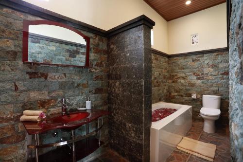 y baño con lavabo rojo, bañera y aseo. en Dewi Sri Private Villa en Ubud