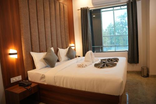 a bedroom with a large bed with a window at Hotel Royal Plaza in Rishīkesh