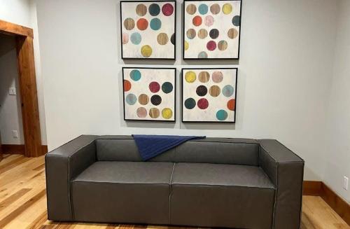 a couch in a room with four paintings on a wall at Mountain Lodge Oasis w Hot Tub-Rio Grande Trail in Carbondale