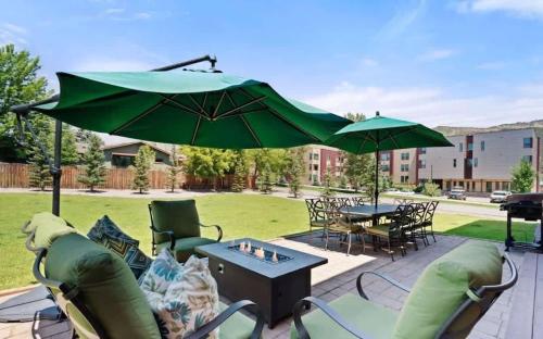 a patio with chairs and a table with an umbrella at Mountain Lodge Oasis w Hot Tub-Rio Grande Trail in Carbondale
