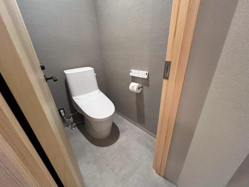 a bathroom with a white toilet in a stall at 日々の宿 ひねもす in Tamano
