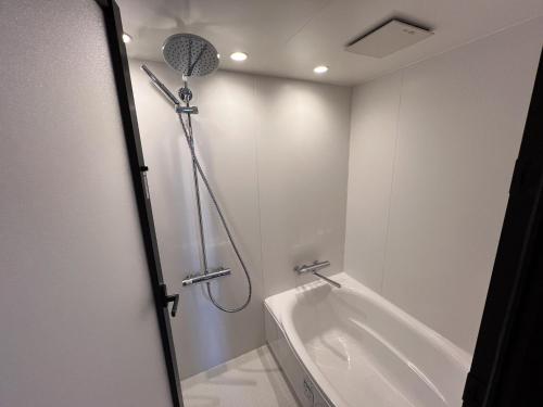 a bathroom with a shower and a bath tub at 日々の宿 ひねもす in Tamano