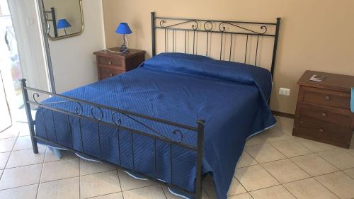 a bedroom with a bed with a blue comforter at Home Rosal Schisò Beach in Giardini Naxos