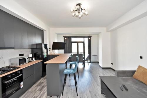 a kitchen with black cabinets and a table and chairs at Komitas Comfort and Charm in Yerevan