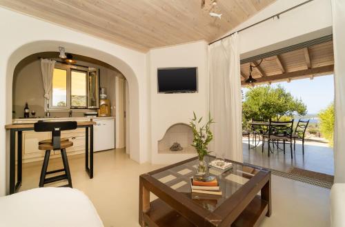 a living room with a table and a kitchen at COTTAGE BLUE in Pylos