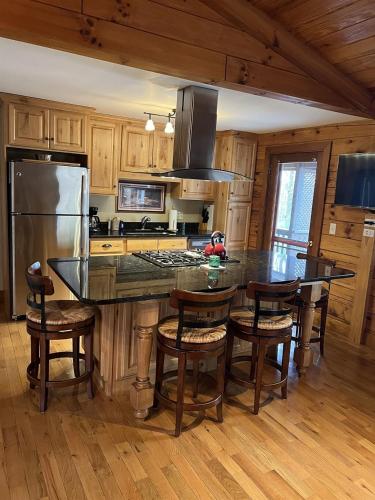 a kitchen with a large island with bar stools at Log Cabin in Bailey Camp