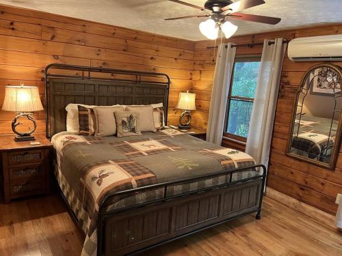 a bedroom with a bed and a ceiling fan at Log Cabin in Bailey Camp