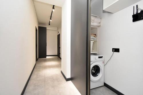 a hallway with a washing machine and a mirror at Komitas Comfort and Charm in Yerevan