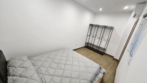 Habitación blanca con cama en la esquina en Optimus Caura, en Coria del Río