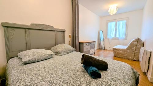 a bedroom with a large bed and a chair at Pies Cottage - Proche Ile aux Pies in Saint-Vincent-sur-Oust