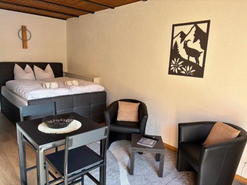 una stanza con un letto, un tavolo e delle sedie di Auberge Les Rangs a Conthey